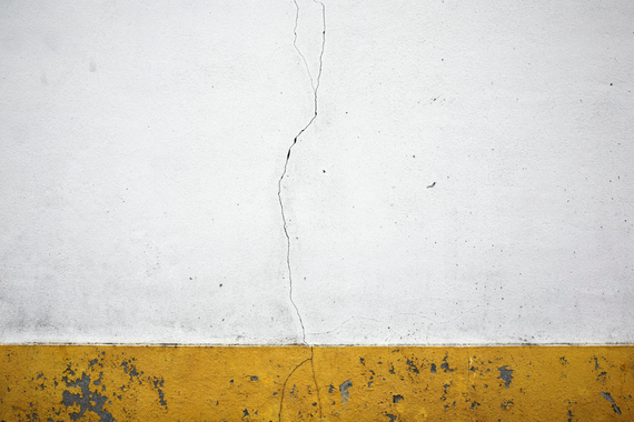 Fine art photograph of white wall with crack and yellow stripe