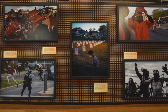 Five photos hanging on display from the Documenting a Reckoning exhibit