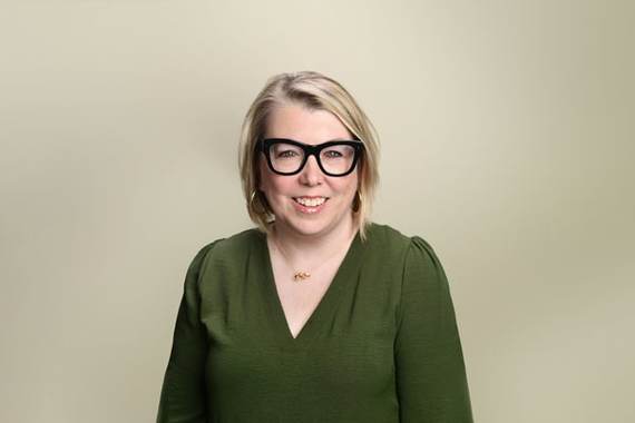 Andrea Mokros, a white woman with blonde hair, wearing a green shirt