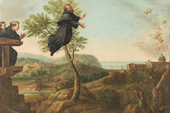A man wearing a black robe flies through the sky and crosses in front of a tree. Two men also in black robes look on. The landscape is pastoral.