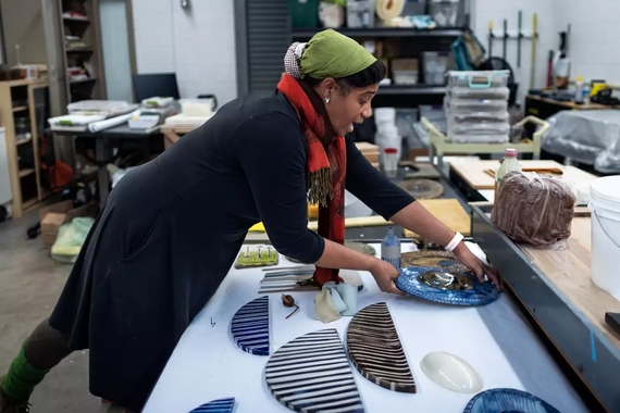 Chotsani Elaine Dean arranges ceramic works on a table in her studio