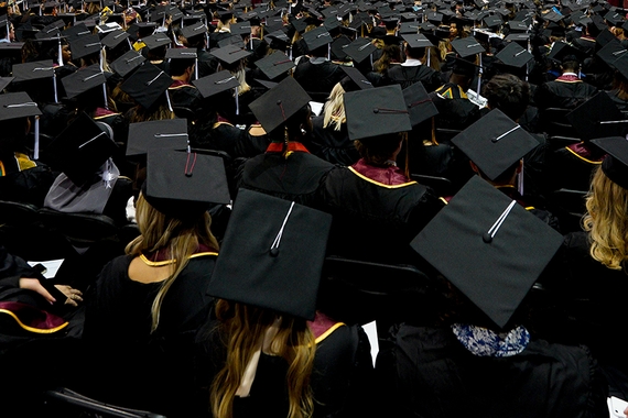 Students in caps & gowns, facing away from camera