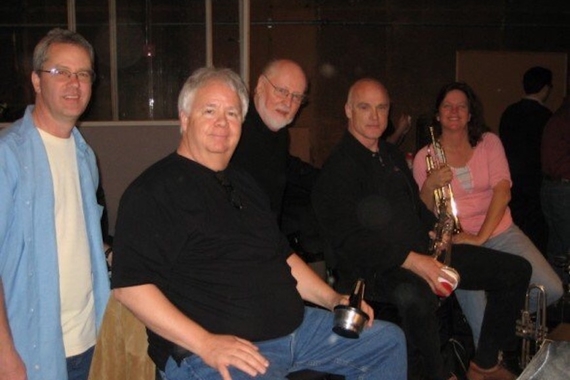 Marissa Benedict (far right in peach shirt) poses with section members and famous composer John Williams