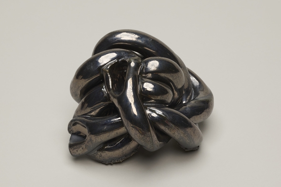 Sculpture of coiled knots in shiny metallic glaze