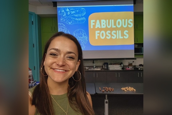 Madelaine Walker standing in front of a screen that says "Fabulous Fossils" 
