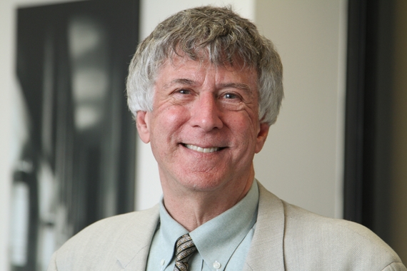 Mark Snyder, a white man with gray hair wearing a cream suit, smiles