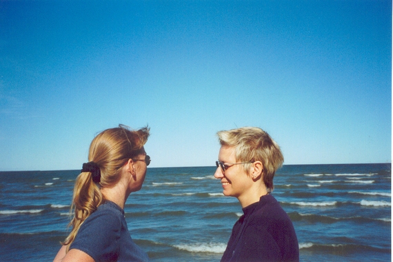 Photograph of two people facing each other and standing at an ocean beach