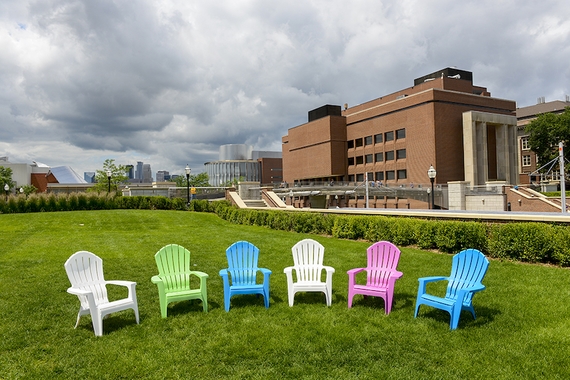 Different colored chairs on a lawn.