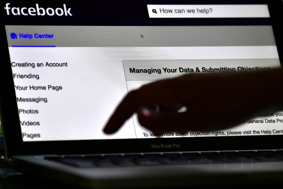a hand typing on a laptop that is open on Facebook's home page, with the words "How can we help?" in the search bar