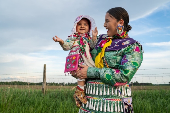 Shawna Olson and her 19-month-old daughter Ariya of the Brokenhead Ojibway Nation of Manitoba, Canada, stand in their jingle dresses