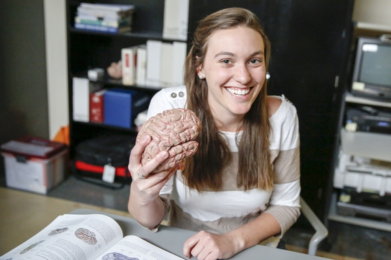 SLHS student with a model of a brain