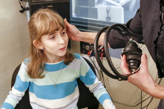 A person giving a hearing test to a child
