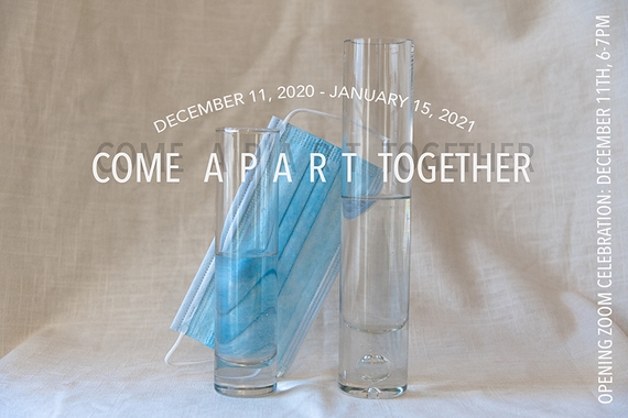 Photograph of two narrow vials of water with a disposable paper mask resting in the background behind them.