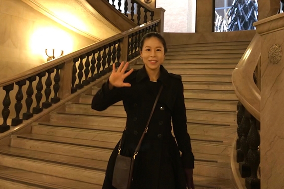 PhD candidate Bomi Jeon on staircase, waving