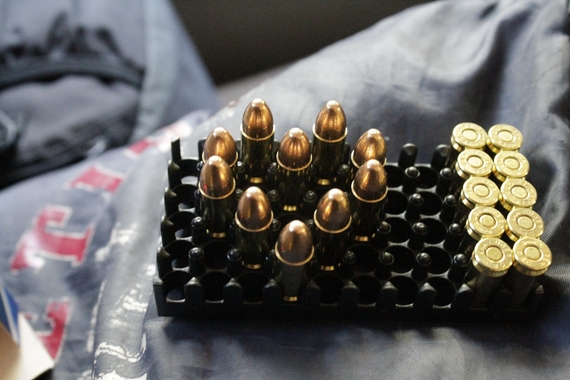 a set of gold-tipped bullets sits on top of a grey sweatshirt