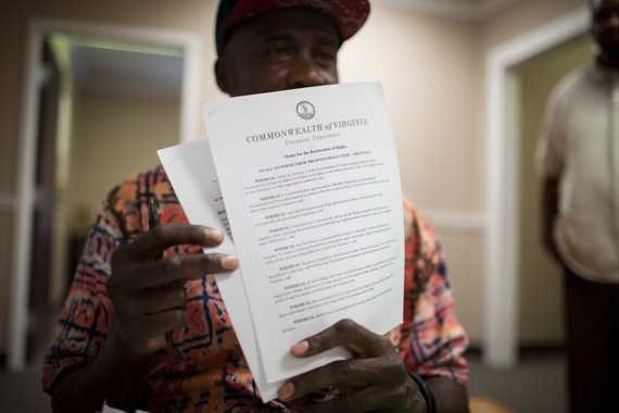 Assadique Abdul-Rahman, an organizer for a liberal advocacy group in Virginia, held up a copy of an executive order that restored voting rights to felons there in 2016.