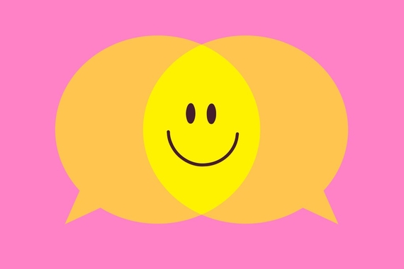 Two neon speech bubbles meeting in the middle to create a cartoon smiley face.
