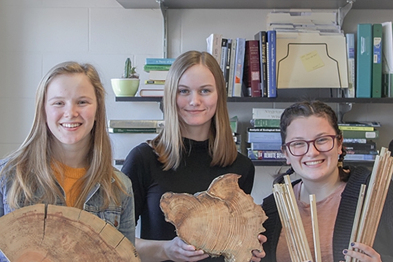 Photo of Suzanne Scotty, Cait Bell, and Madison Pettersen holding tree core samples