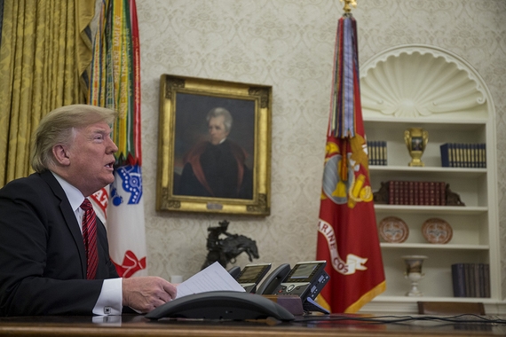 Donald Trump sitting at the desk in the Oval Office, staring open-mouthed into the distance