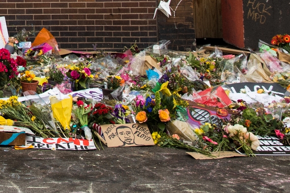 Close-up of flowers and signs at memorial for George Floyd