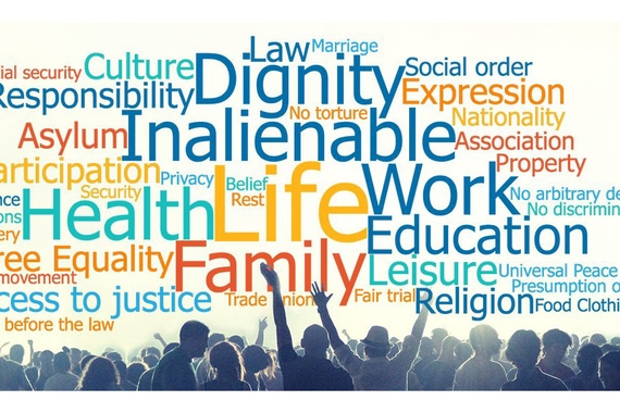 Tag cloud with multi-colored words related to human rights with people standing in foreground waving arms and cheering