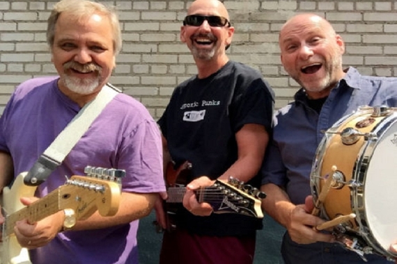 Members of The Hypoxic Punks holding instruments and smiling at camera