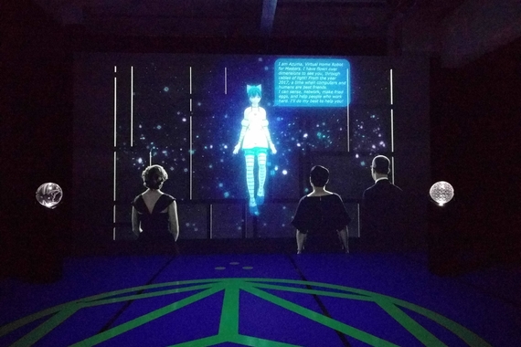 A projection of three figures looking at a female drawn in the anime style