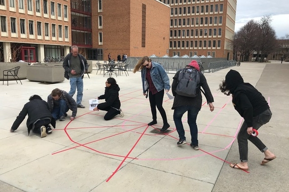 Students in an undergraduate Art History course used colored gaff tape in a courtyard on campus to create a to-scale floor plan of a medieval cathedral.