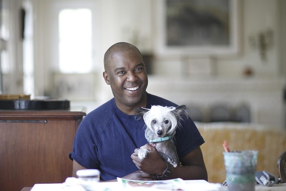 Lamar Peterson with his small black and white dog, Moo, in his lap.