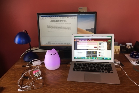 Photo of Prof Josephine Lee's desk with eyeglasses and pink plastic cat