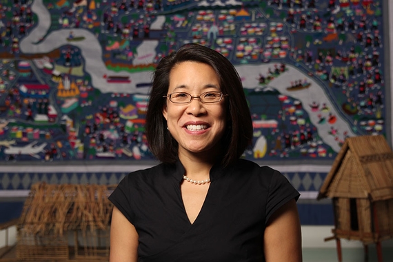 Portrait: Erika Lee pictured in front of an embroidered tapestry depicting Hmong history