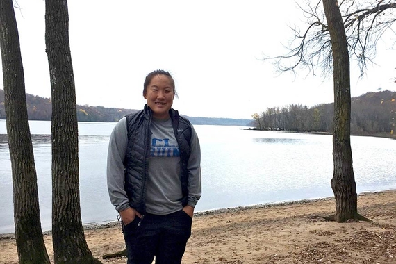 M. Chip Chang standing in the woods near a lake. 