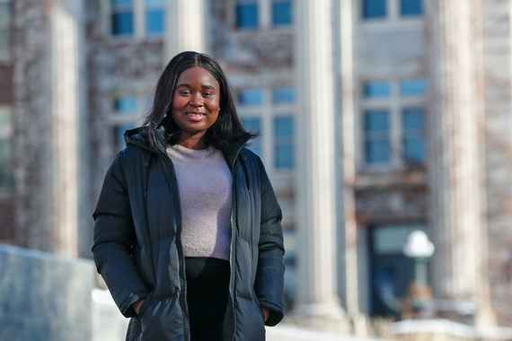 Photo of Gbemi Oyetunde standing outside on a winter day with Morrill Hall in the background