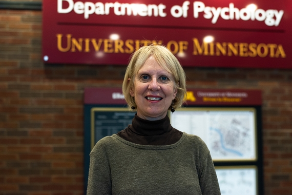 Photo of Patricia Frazier standing in front of the Department of Psychology sign
