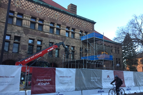 Photo of Pillsbury Hall with construction fences up and red crane
