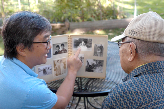Rich Lee and father looking at old photo album