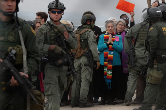 U.S. Border Patrol agents hold a line during a pro-migration protest by members of various faith groups showing support for Central American asylum-seekers 