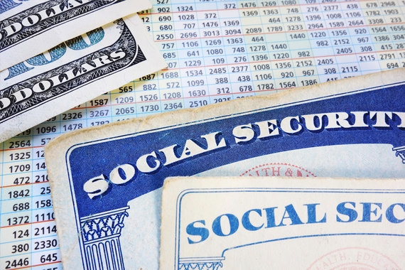 Close up of Social Security cards, American dollars, and a spreadsheet lying on a table