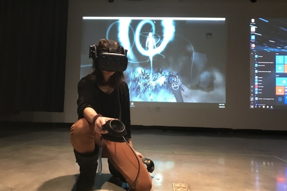 Melinda Hiller works in VR to create the drawings that are projected behind her.