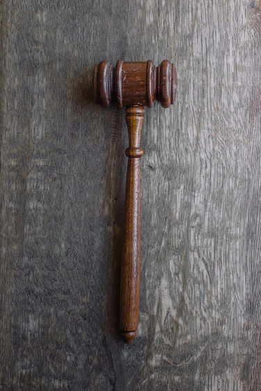 Brown wooden gavel against gray wooden background