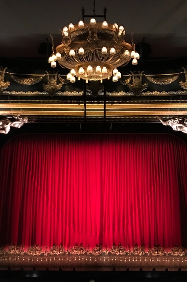 Large theatre stage with gold pillars and red curtains