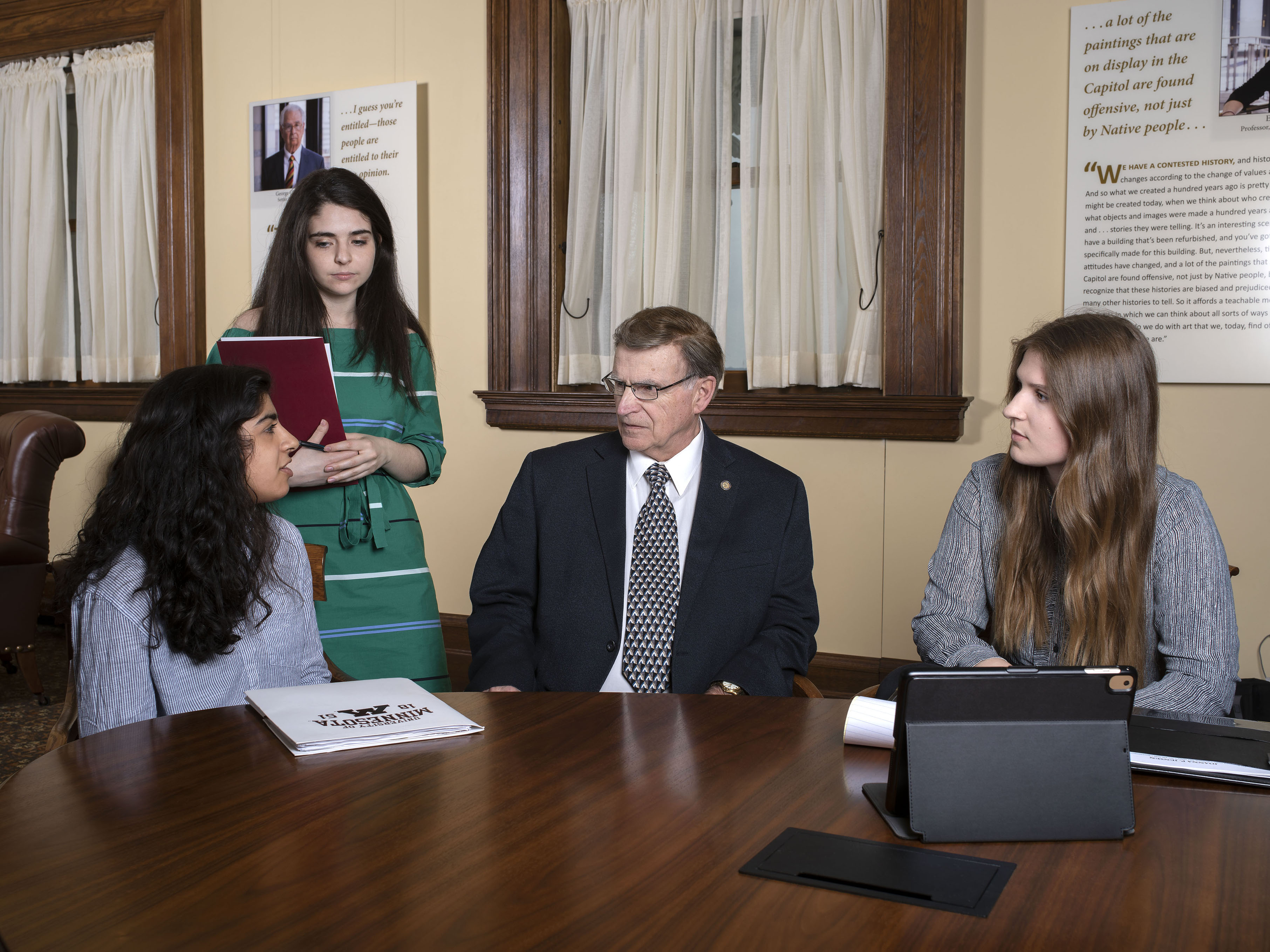 Three students meet with State Representative in the Minnesota capitol building.