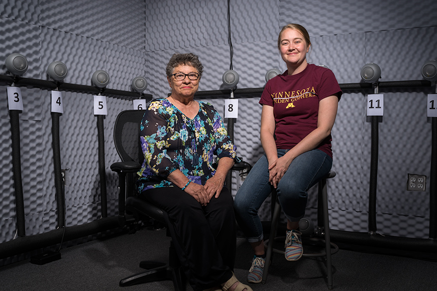 Two women, one older one younger, sitting on chairs in a CATSS lab with microphones and padding on the walls