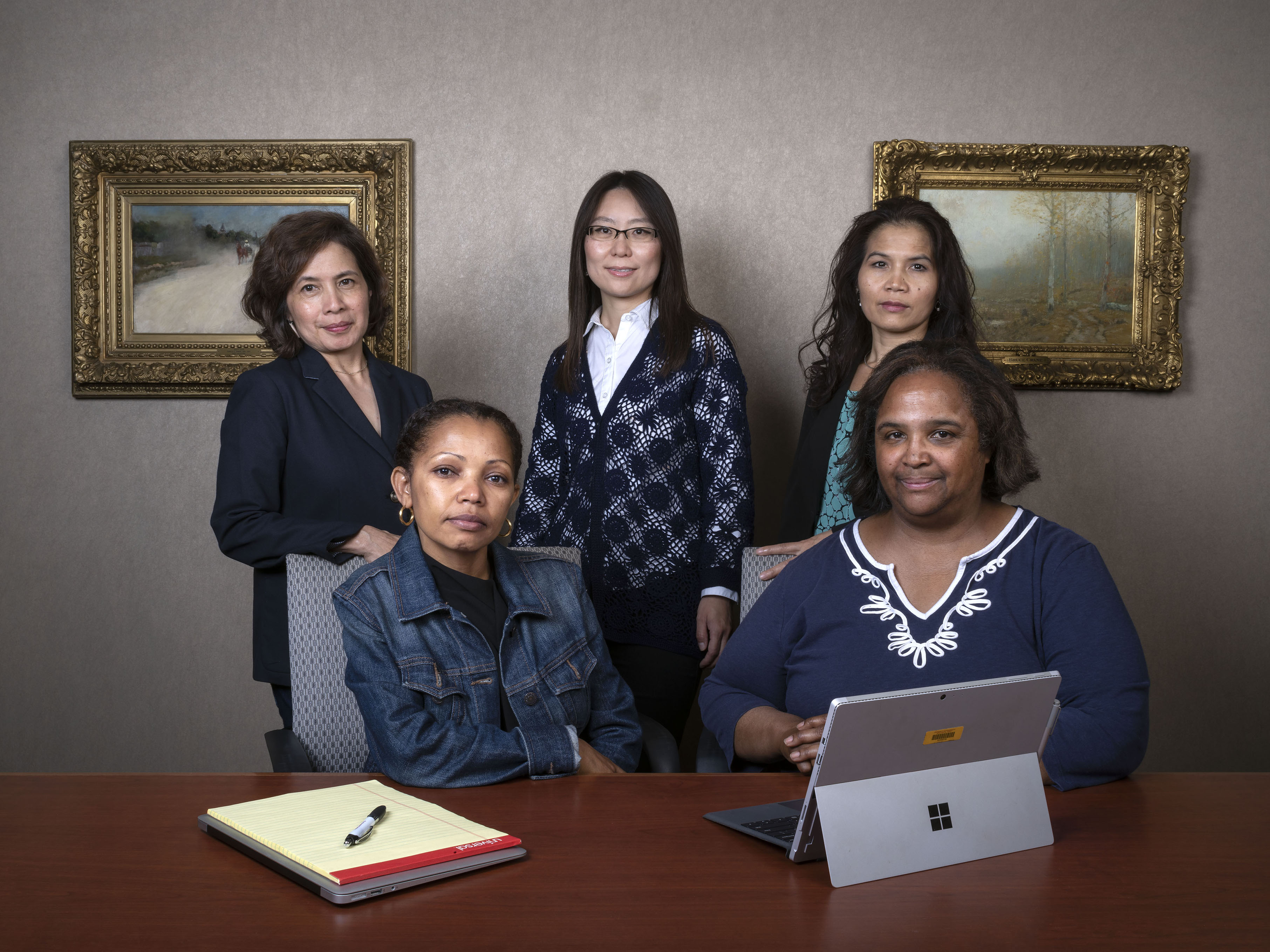 Five staff members gather in a board room facing the camera.