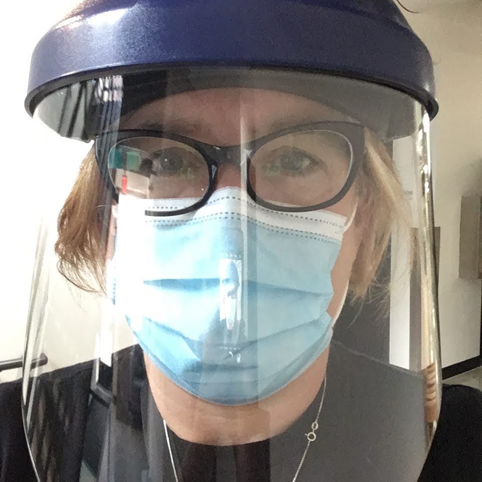 selfie of a person wearing surgical mask, glasses and face shield