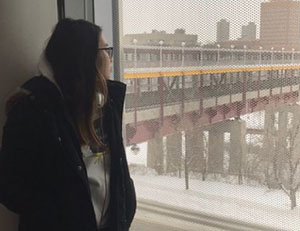Image of student Samantha Keo looking out window at Washington Ave bridge