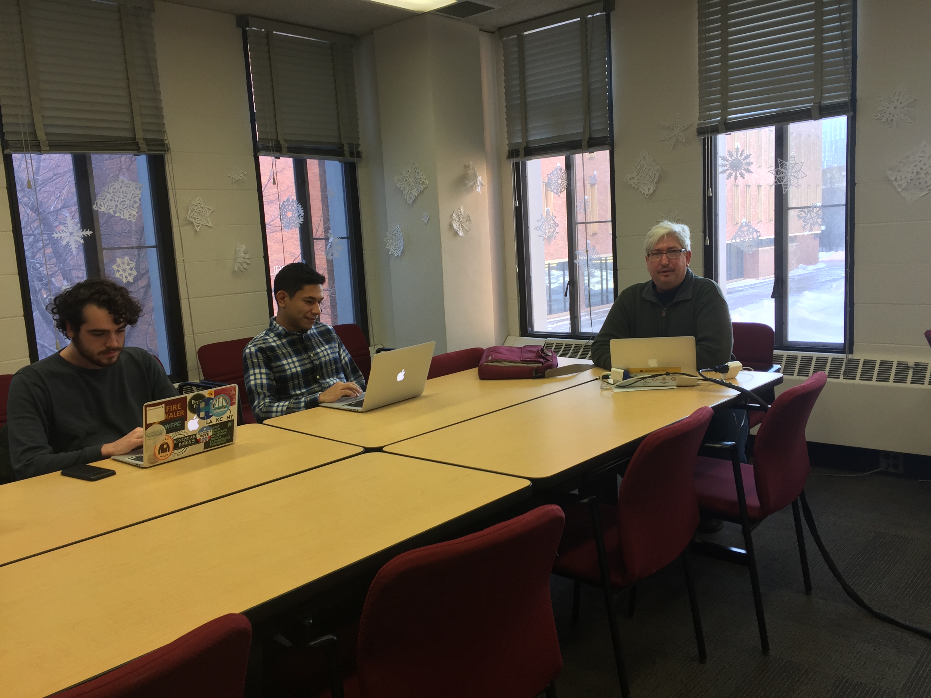 White male professor meeting with two male students