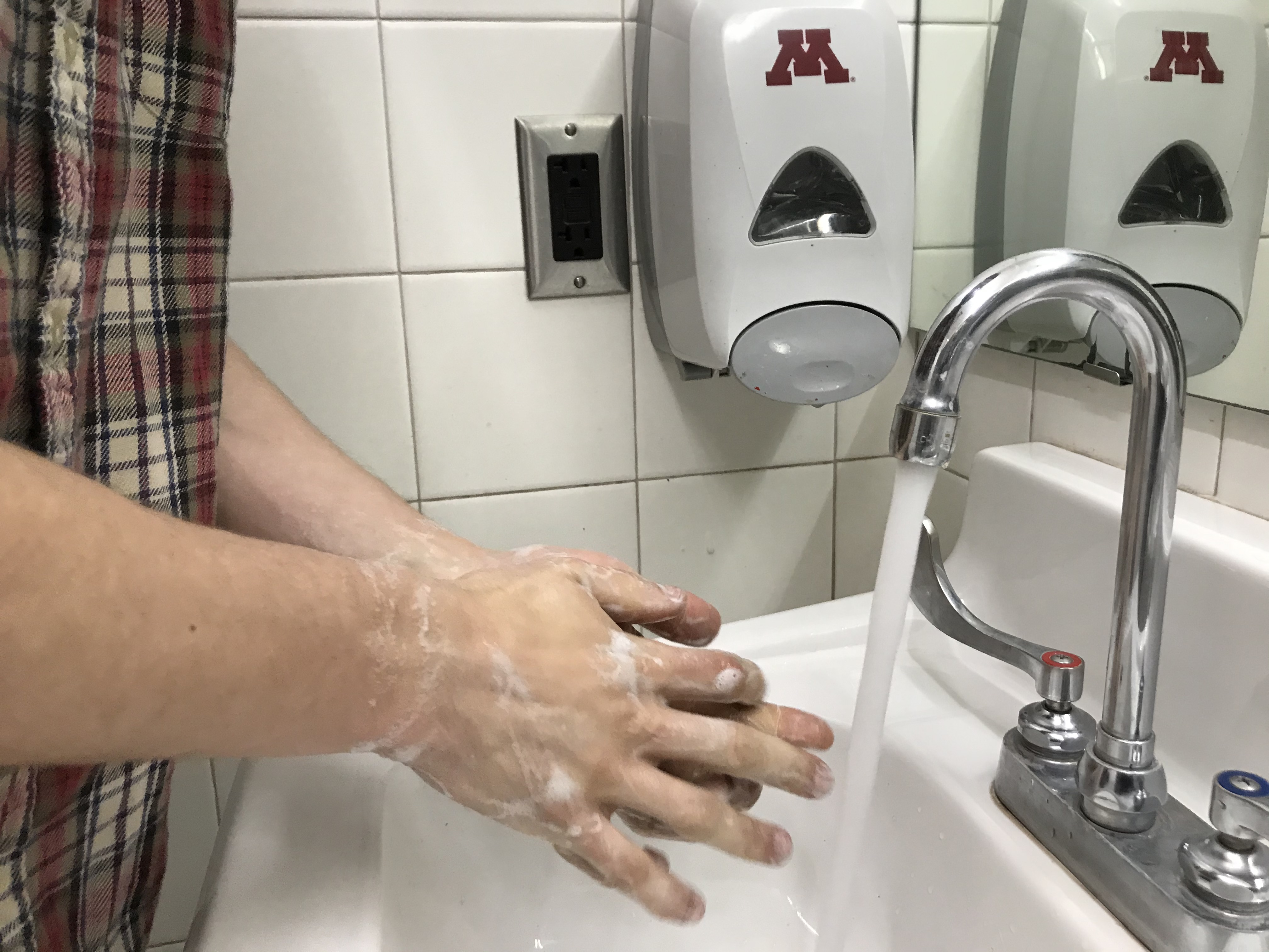 Hand washing with UMN logo on soap dispenser